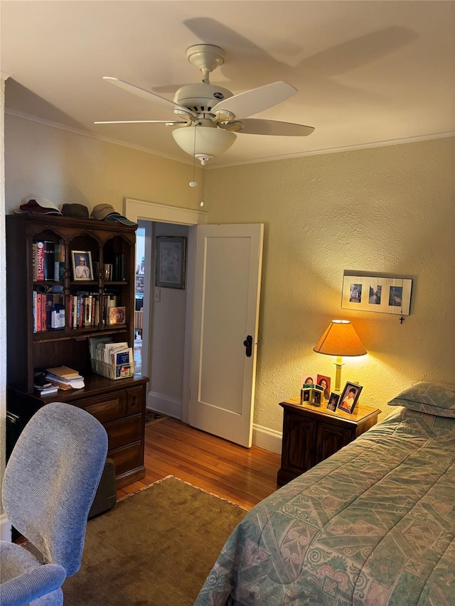 bedroom featuring ornamental molding, dark hardwood / wood-style floors, and ceiling fan