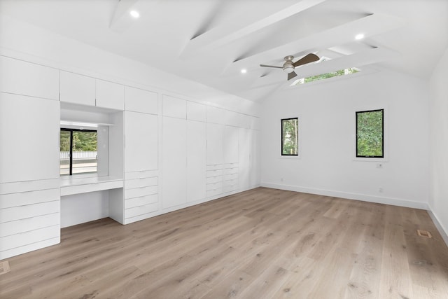 unfurnished bedroom with ceiling fan, built in desk, multiple windows, and light hardwood / wood-style floors