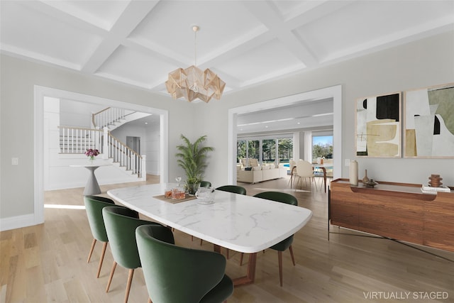 dining room with beamed ceiling, coffered ceiling, a chandelier, and light wood-type flooring