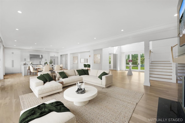 living room with light hardwood / wood-style flooring and ornamental molding