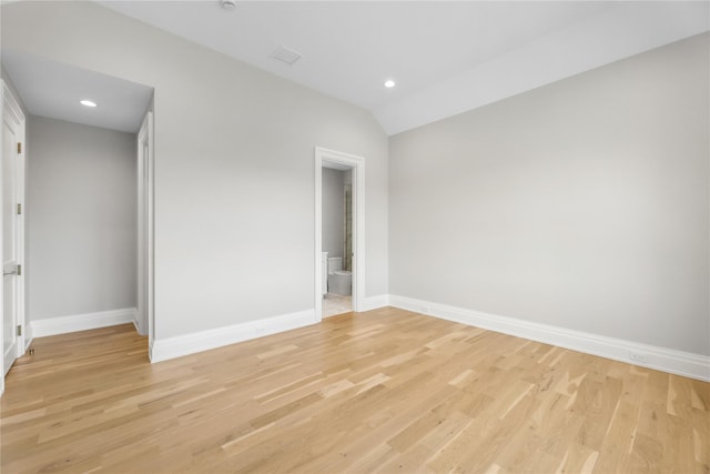 unfurnished bedroom with lofted ceiling, light hardwood / wood-style flooring, and ensuite bathroom