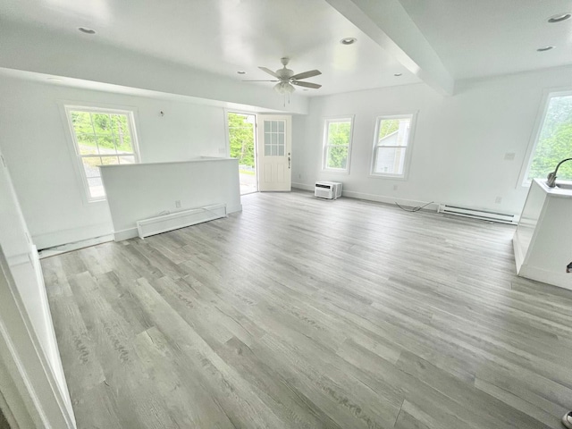 unfurnished living room featuring ceiling fan, a wall mounted AC, light hardwood / wood-style floors, a baseboard radiator, and beamed ceiling