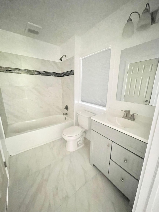 full bathroom featuring tiled shower / bath combo, vanity, and toilet