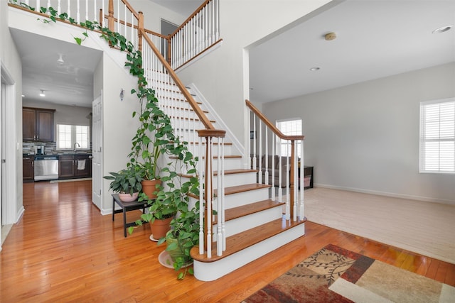 staircase with sink, hardwood / wood-style flooring, and plenty of natural light