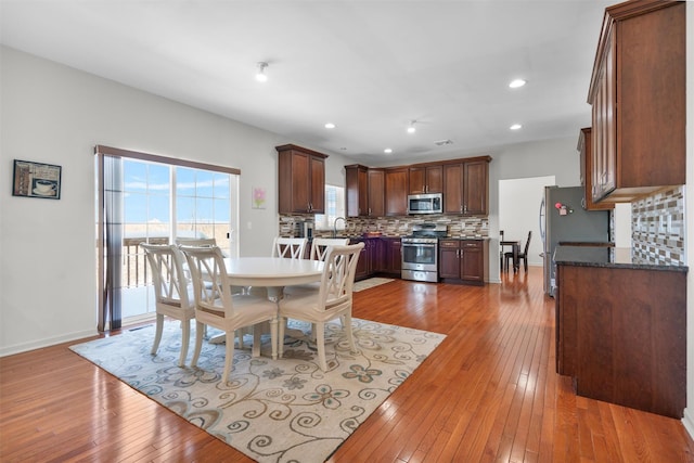 dining space with wood-type flooring and sink