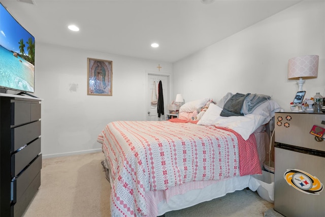 carpeted bedroom with stainless steel refrigerator