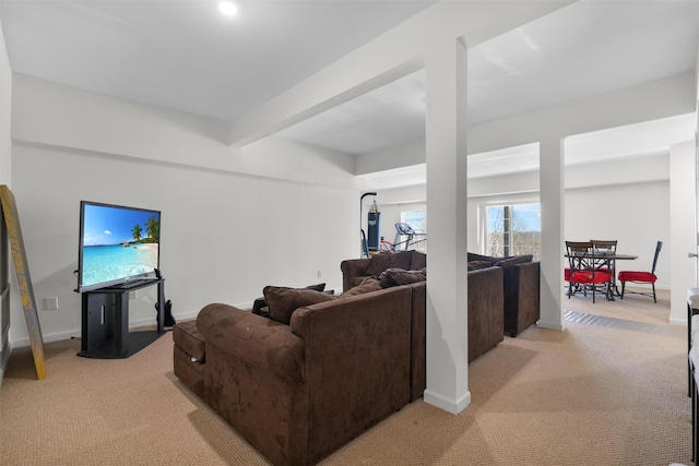 carpeted living room featuring beamed ceiling