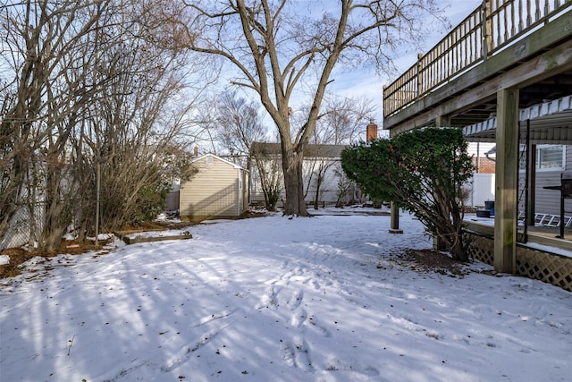 yard covered in snow with a storage shed