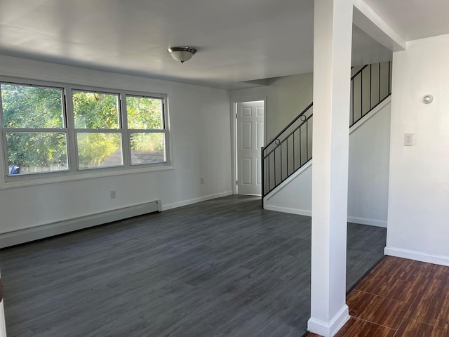 unfurnished living room featuring a baseboard heating unit and dark hardwood / wood-style floors