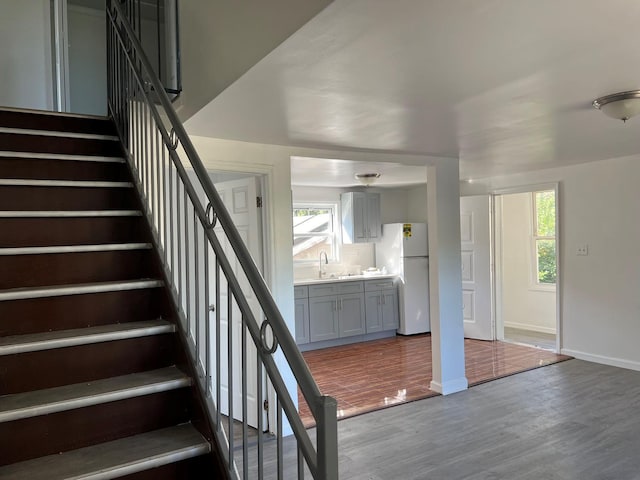 stairs featuring hardwood / wood-style flooring and sink