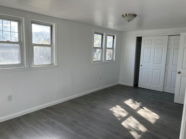 unfurnished bedroom with dark wood-type flooring and a closet