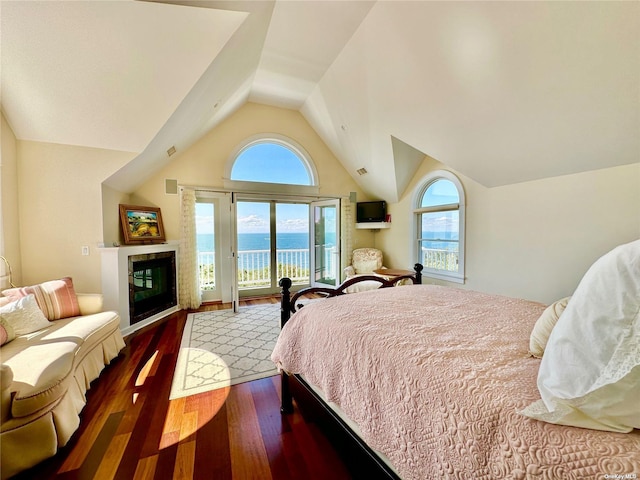 bedroom with access to exterior, dark wood-type flooring, a fireplace, and lofted ceiling