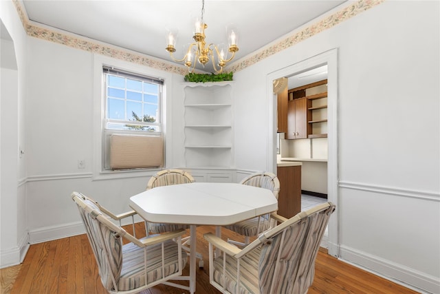 dining area featuring a notable chandelier and light wood-type flooring