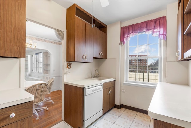 kitchen with light tile patterned flooring, plenty of natural light, white dishwasher, and sink