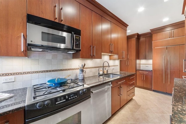 kitchen with dark stone countertops, sink, appliances with stainless steel finishes, and tasteful backsplash