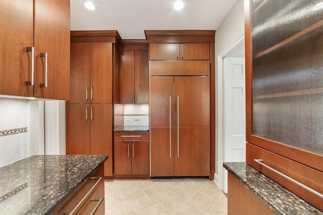 kitchen featuring dark stone countertops and paneled fridge