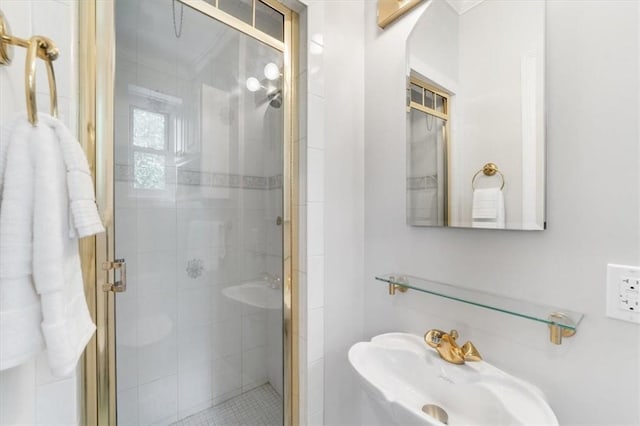 bathroom with a shower with shower door and sink