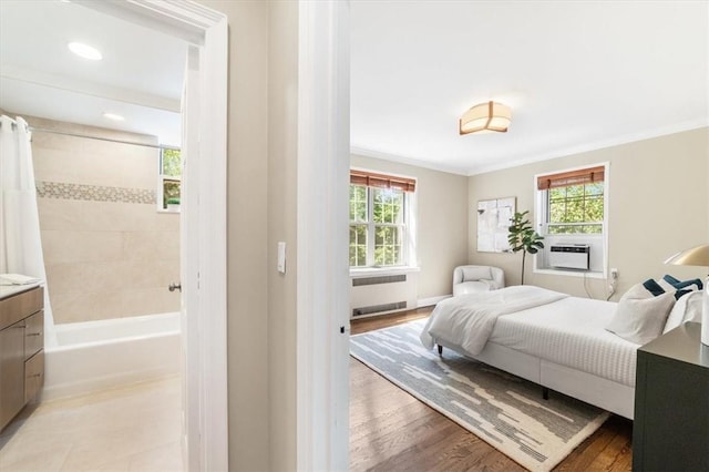 bedroom with radiator, crown molding, cooling unit, and light wood-type flooring