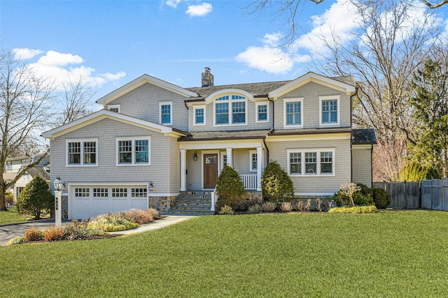 shingle-style home featuring fence, a front yard, a chimney, driveway, and an attached garage