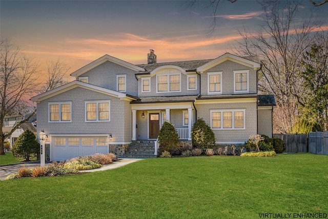 shingle-style home featuring a front yard, fence, a chimney, concrete driveway, and a garage