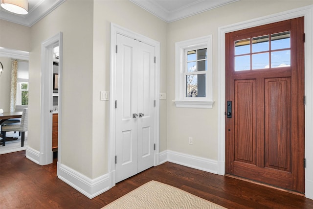 foyer entrance with dark wood-style floors, baseboards, and ornamental molding