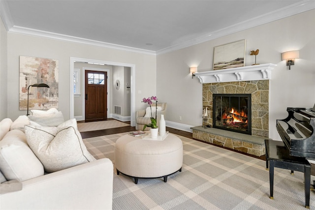 living area with visible vents, a fireplace, crown molding, and baseboards