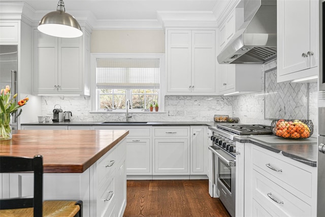 kitchen with a sink, stainless steel stove, crown molding, wall chimney range hood, and wooden counters