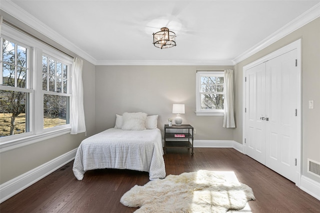 bedroom featuring dark wood finished floors, baseboards, and ornamental molding