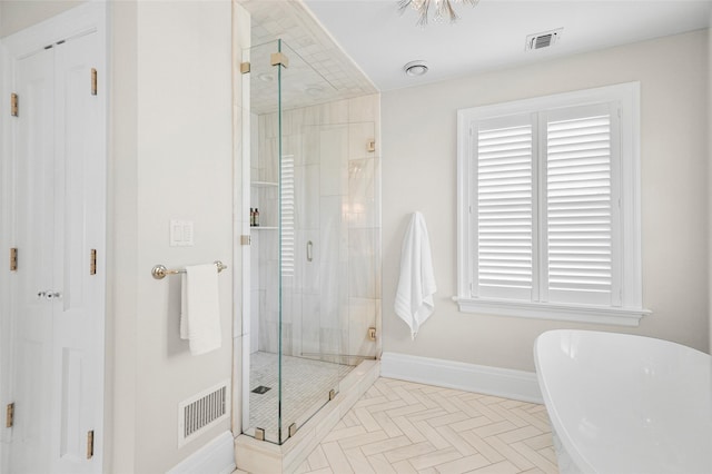 bathroom featuring a soaking tub, visible vents, plenty of natural light, and a stall shower