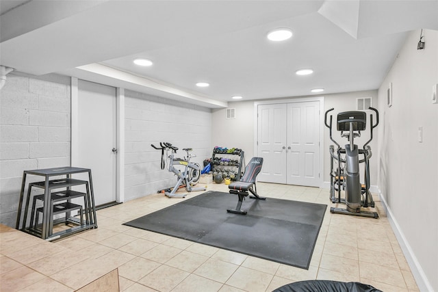 workout area with recessed lighting, visible vents, concrete block wall, and tile patterned flooring