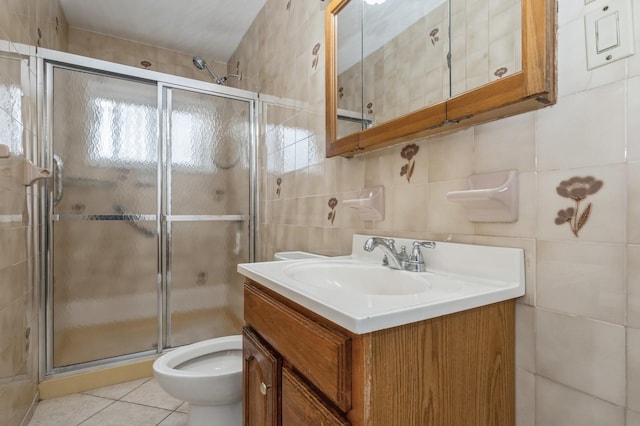 bathroom featuring toilet, a shower with shower door, tile walls, tile patterned floors, and vanity