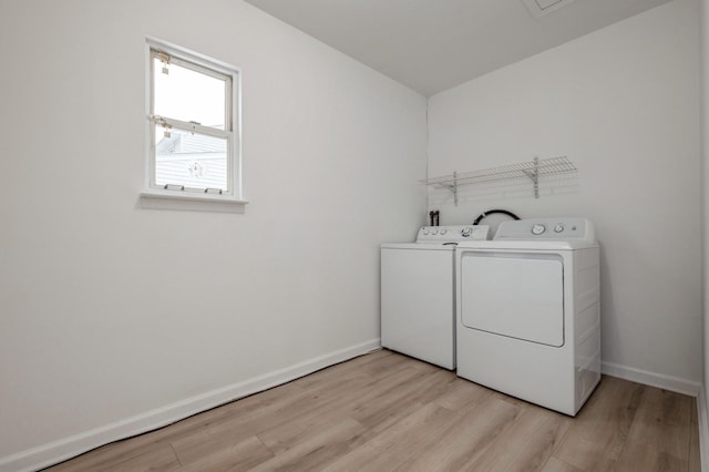 laundry area featuring light wood-type flooring and separate washer and dryer