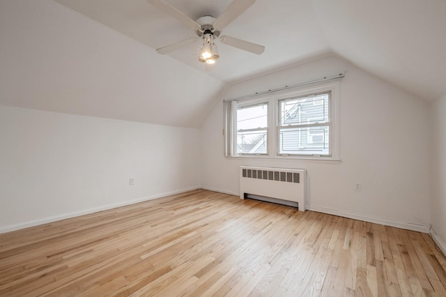 additional living space with radiator, ceiling fan, vaulted ceiling, and light hardwood / wood-style floors