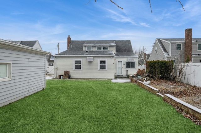 rear view of house featuring a lawn