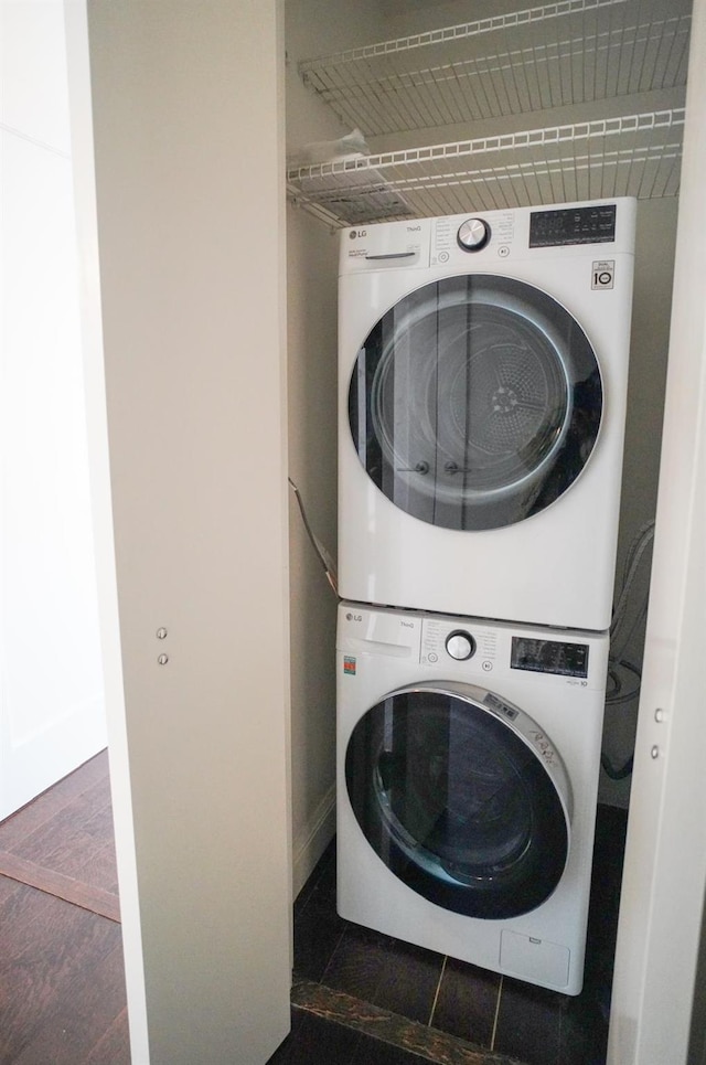 clothes washing area with dark hardwood / wood-style flooring and stacked washing maching and dryer