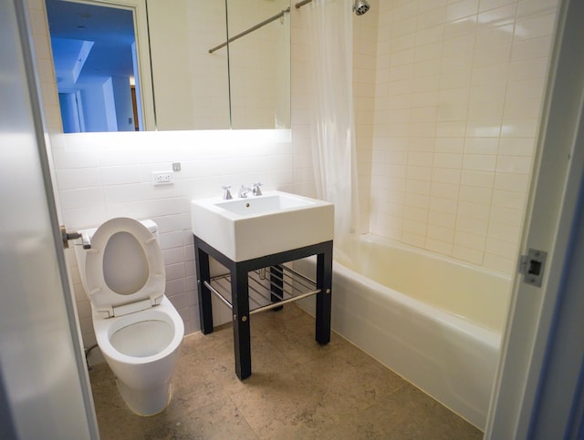 bathroom featuring tile walls, shower / bathtub combination with curtain, and toilet