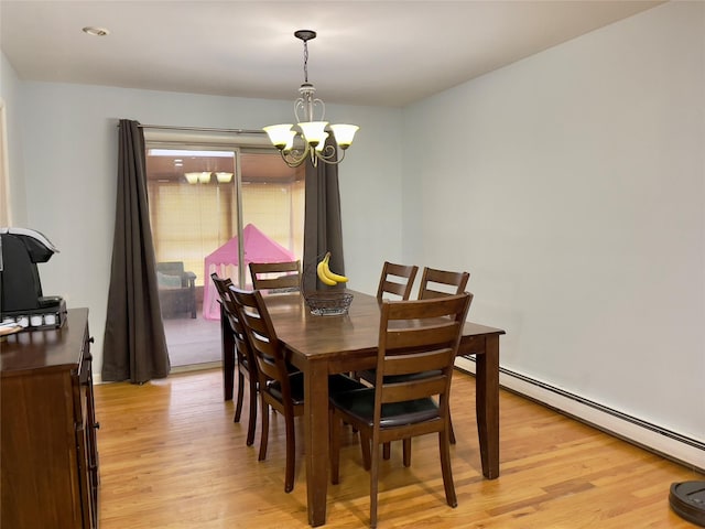 dining space featuring a baseboard heating unit, an inviting chandelier, and light hardwood / wood-style floors