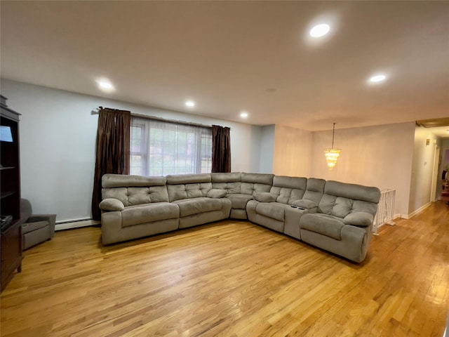 living room featuring baseboard heating, light hardwood / wood-style flooring, and radiator heating unit