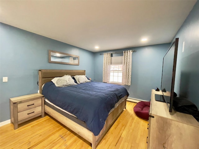 bedroom with a baseboard radiator and light hardwood / wood-style flooring