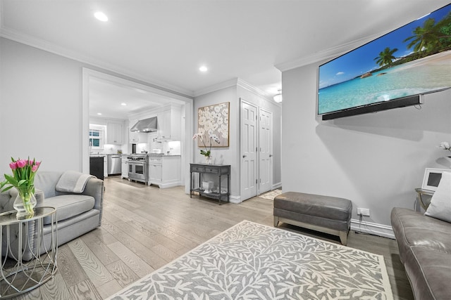 living room featuring crown molding and light hardwood / wood-style flooring