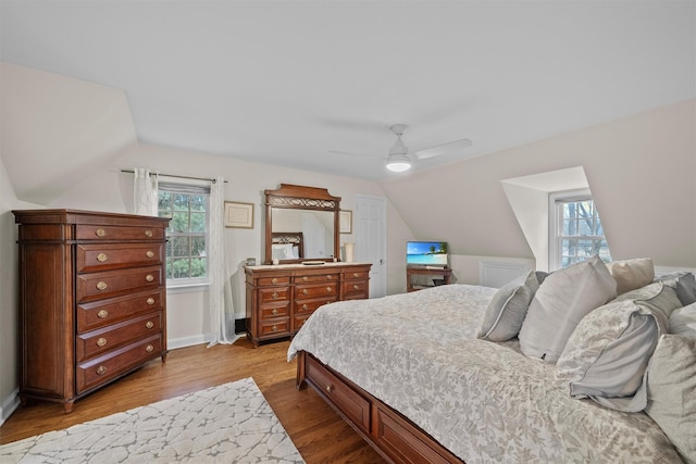 bedroom with ceiling fan, light hardwood / wood-style flooring, and multiple windows