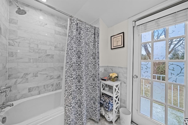 bathroom featuring tile walls and shower / bathtub combination with curtain