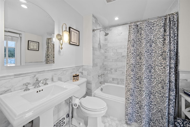 bathroom featuring toilet, tile walls, and shower / tub combo with curtain