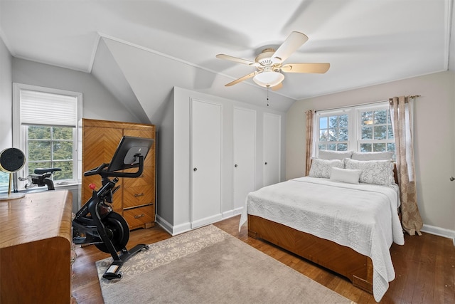 bedroom with ceiling fan, dark wood-type flooring, and lofted ceiling