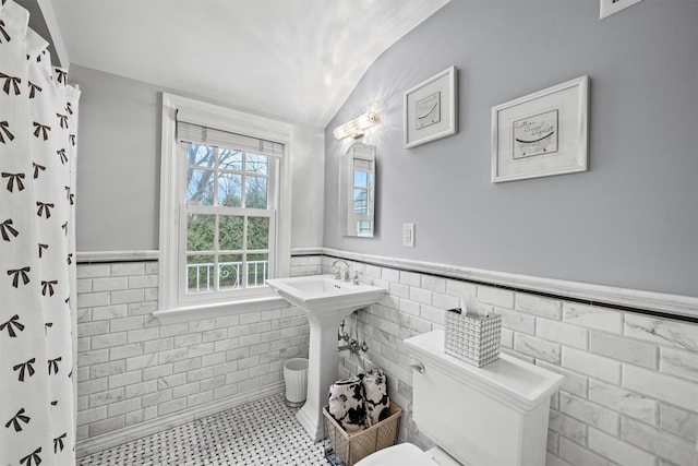 bathroom featuring tile walls, a shower with curtain, and vaulted ceiling