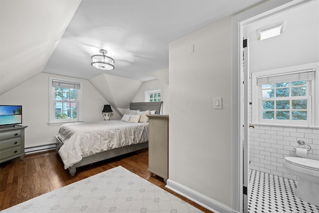 bedroom featuring hardwood / wood-style floors, a baseboard heating unit, and vaulted ceiling