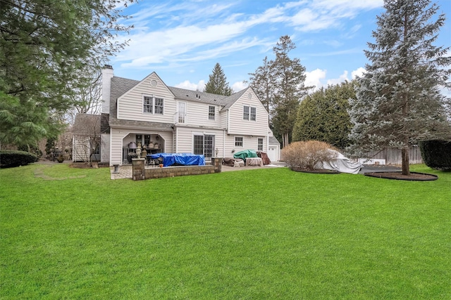 rear view of property featuring a yard, an outdoor living space, and a patio