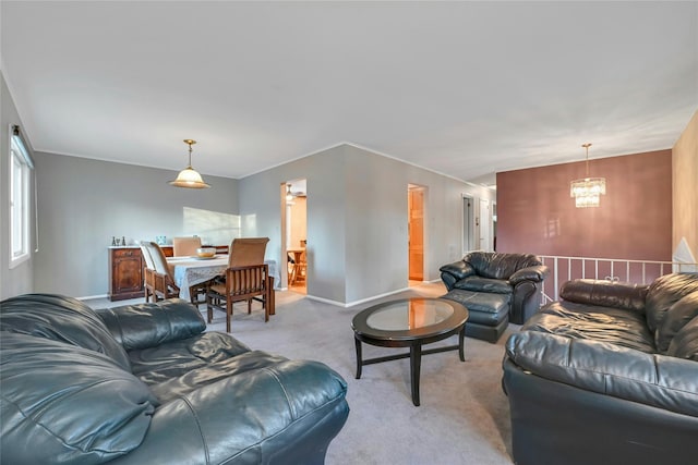 carpeted living room featuring a chandelier