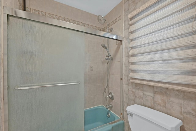 bathroom featuring shower / bath combination with glass door and toilet