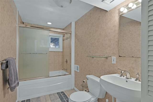 full bathroom with bath / shower combo with glass door, sink, and toilet